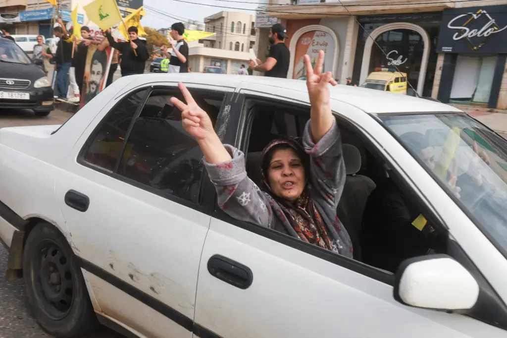A woman celebrates the ceasefire in Lebanon while returning to her home in Nabatieh