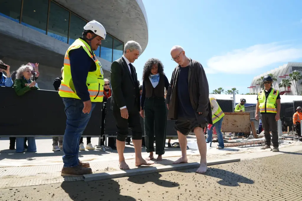 LACMA director Michael Govan and architect Peter Zumthor imprint their feet in the cement floor in Los Angeles.