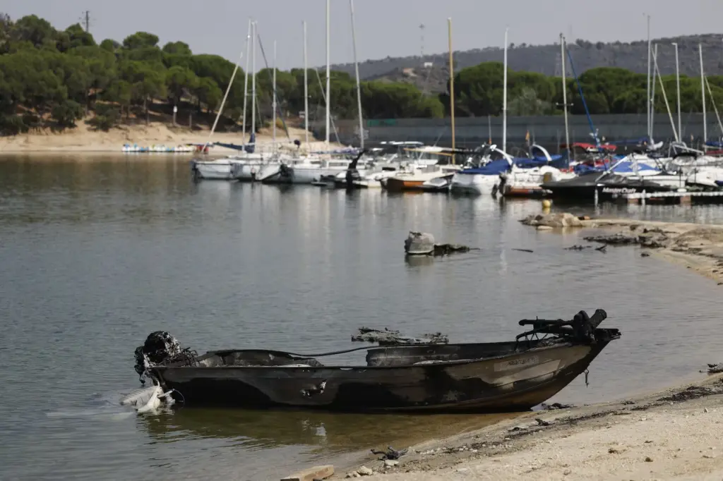 Ash, charred boats, and black water in the San Juan Reservoir after the passage of the flames