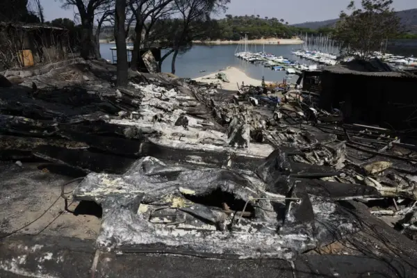 Ash, charred boats, and black water in the San Juan Reservoir after the passage of the flames