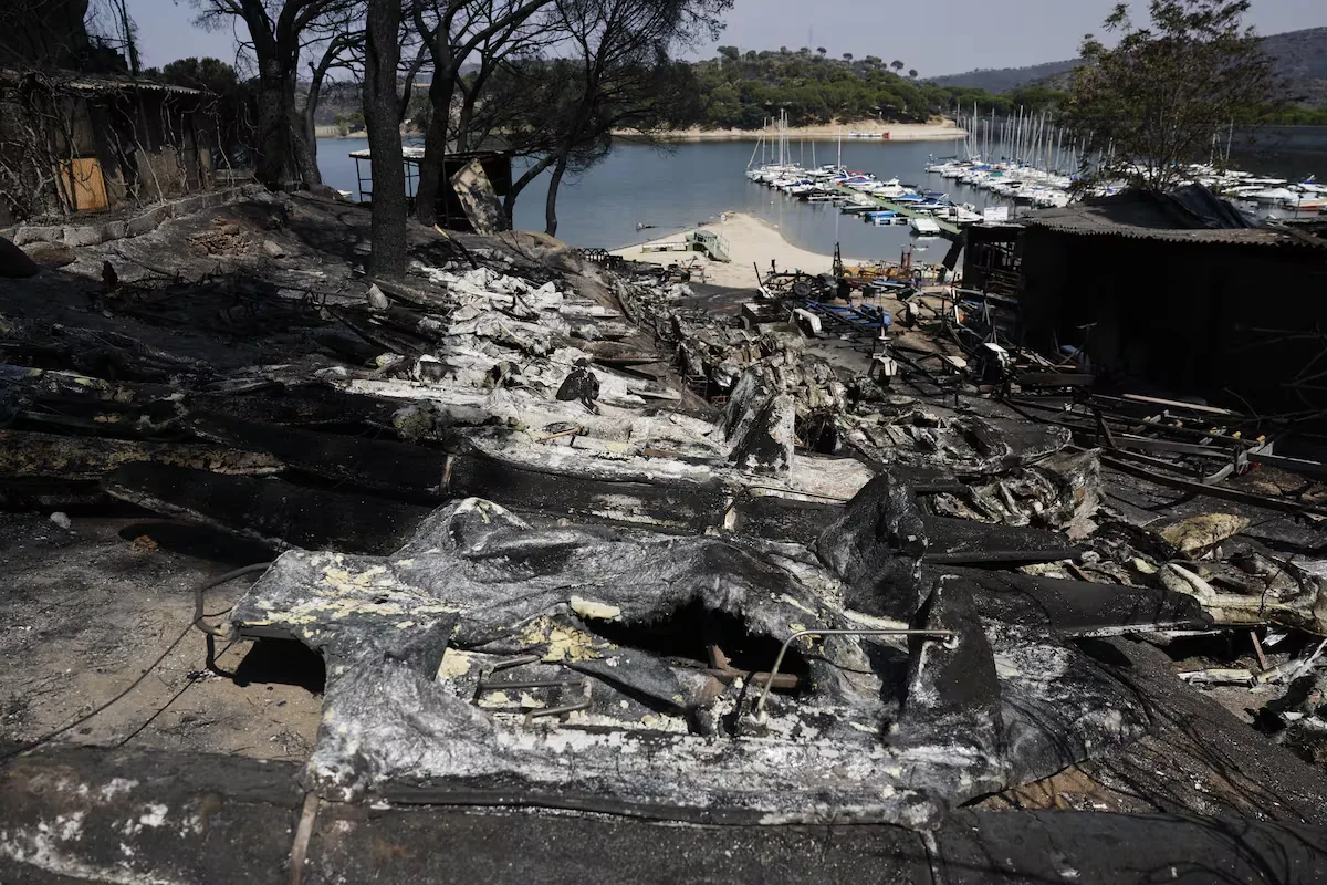 Ash, charred boats, and black water in the San Juan Reservoir after the passage of the flames