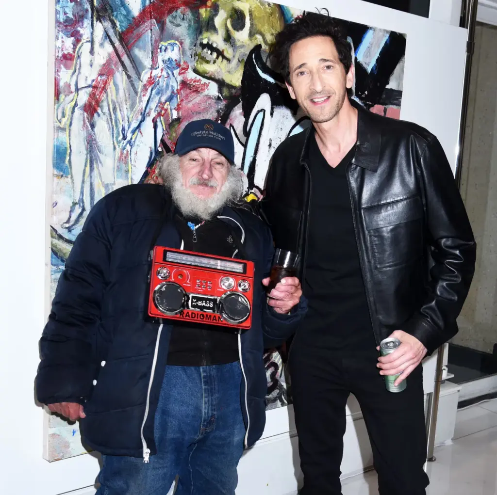 Los críticos se ríen de la obra artística de Adrien Brody: perros con bandana, pollo frito y un mural a lo Warhol
