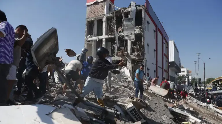 AME7645. CALI (COLOMBIA), 10/08/2026.- People walk over the rubble of a collapsed building this Monday in Cali (Colombia). At least 20 buildings suffered severe damage due to the magnitude 7.4 earthquake that shook most of the country, with the epicenter in the Pacific area. EFE/ Ernesto Guzmán