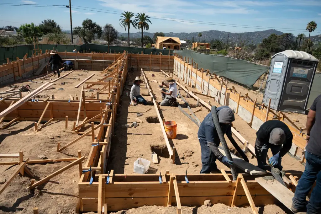 Workers rebuild a home in Altadena, California, this Tuesday.