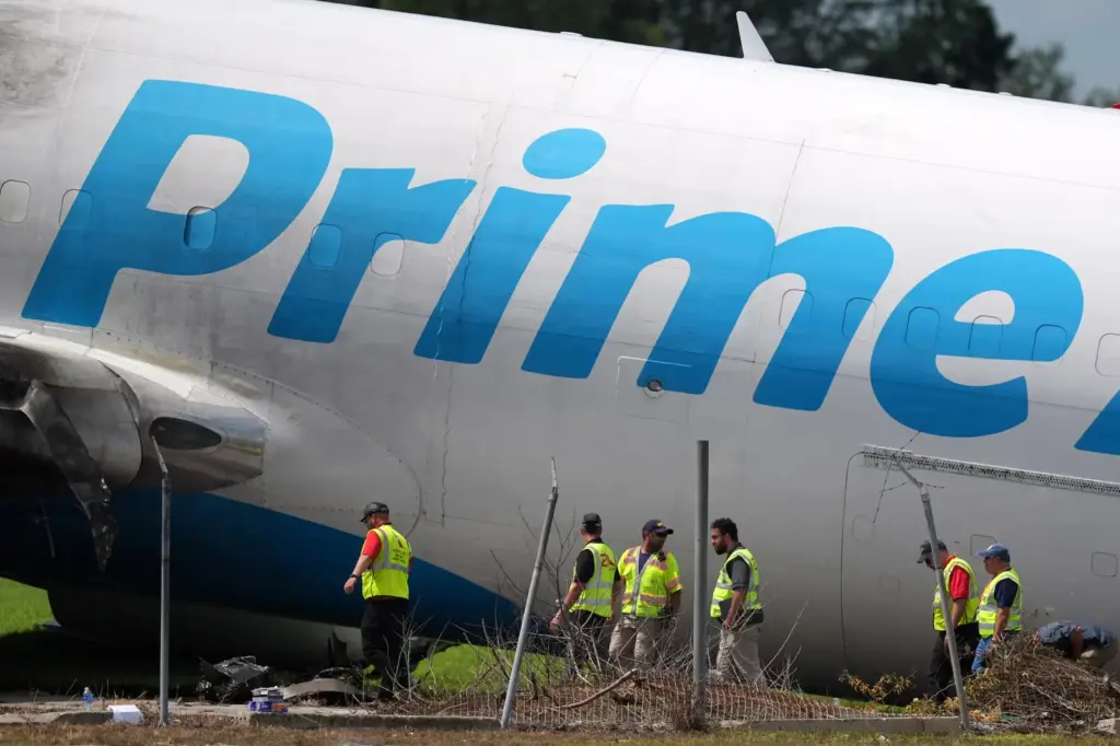 Workers inspect a damaged Amazon cargo plane.