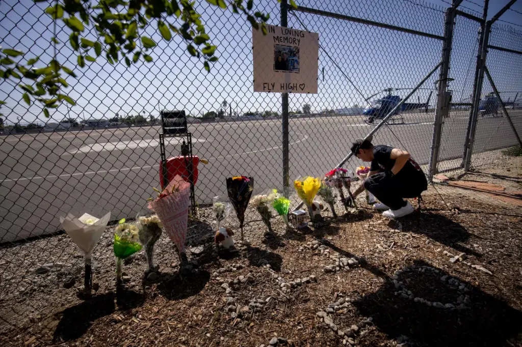 A person arranges flowers at a memorial dedicated to Eliana Moreno and George Marciniw, who died in a helicopter accident, at the place where their helicopter used to park at Whiteman Airport in Los Angeles, Wednesday, September 16, 2026.